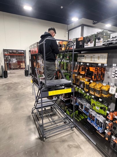 Merchco Service Team Member adding stock to hunting suplies